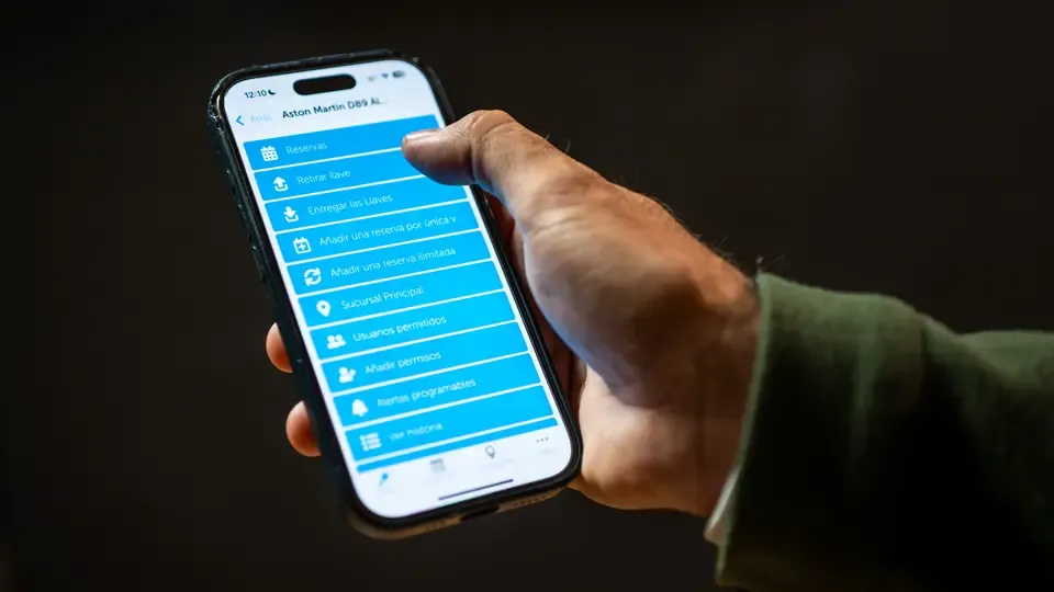 Hand holding a mobile phone using the Keycafe app