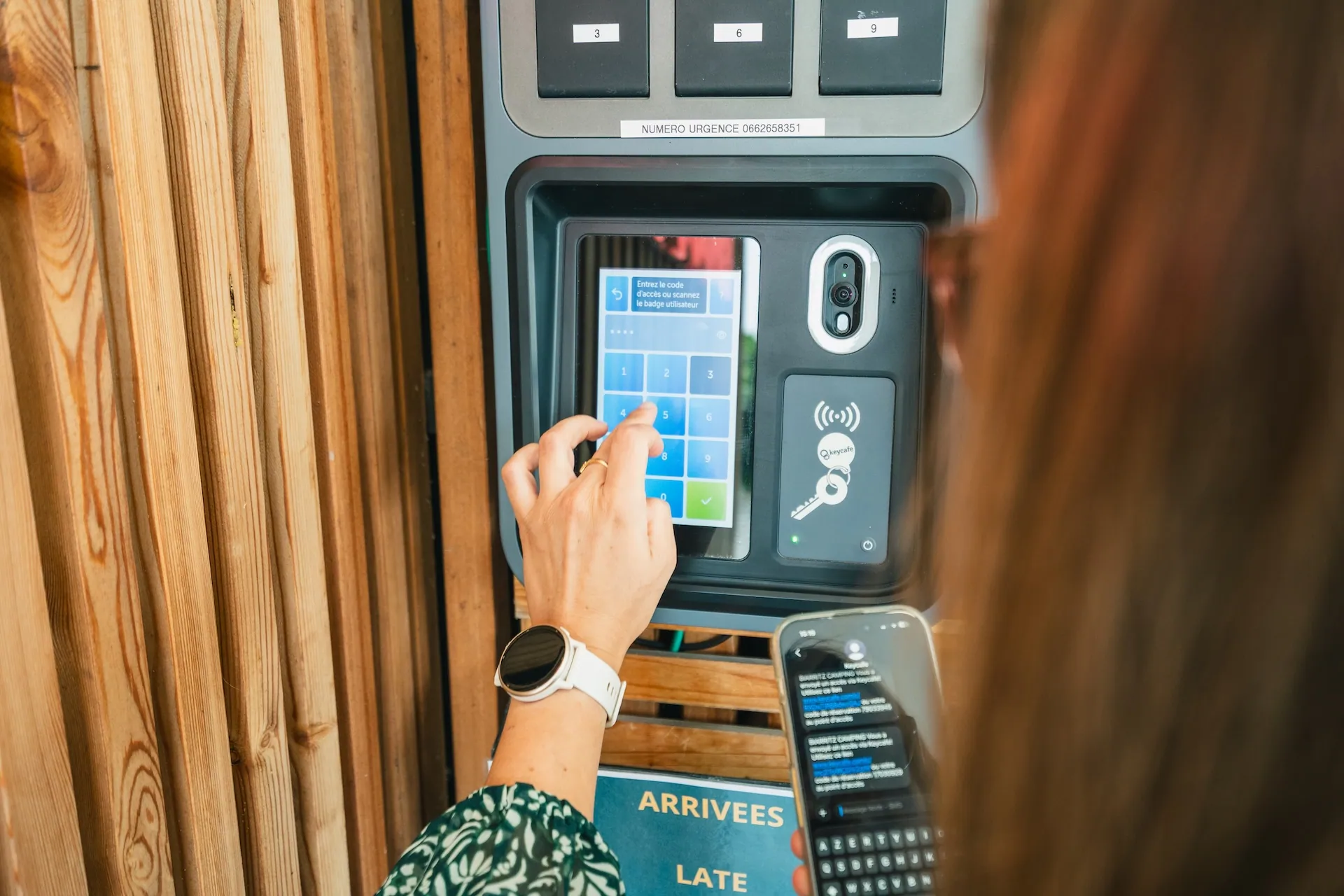 a woman typing down the unique PIN received on her phone to retrive the key from a Keycafe's Smartbox