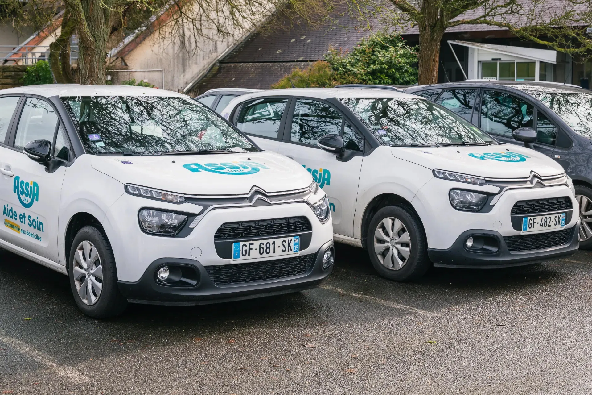 Assia Una branded vehicles in a parking lot