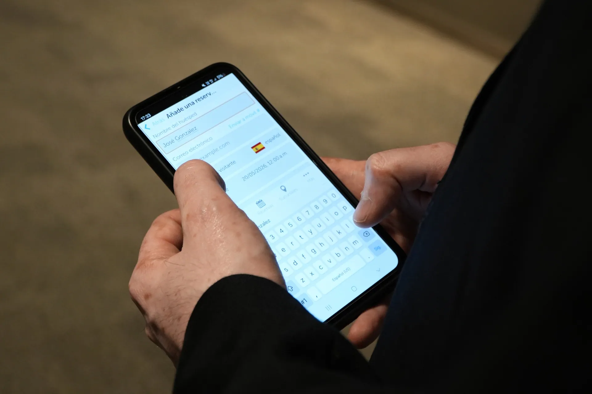 Close-up of an Aeropuertos Uruguay staff member using the Keycafe mobile app to add a new user reservation for airport key access