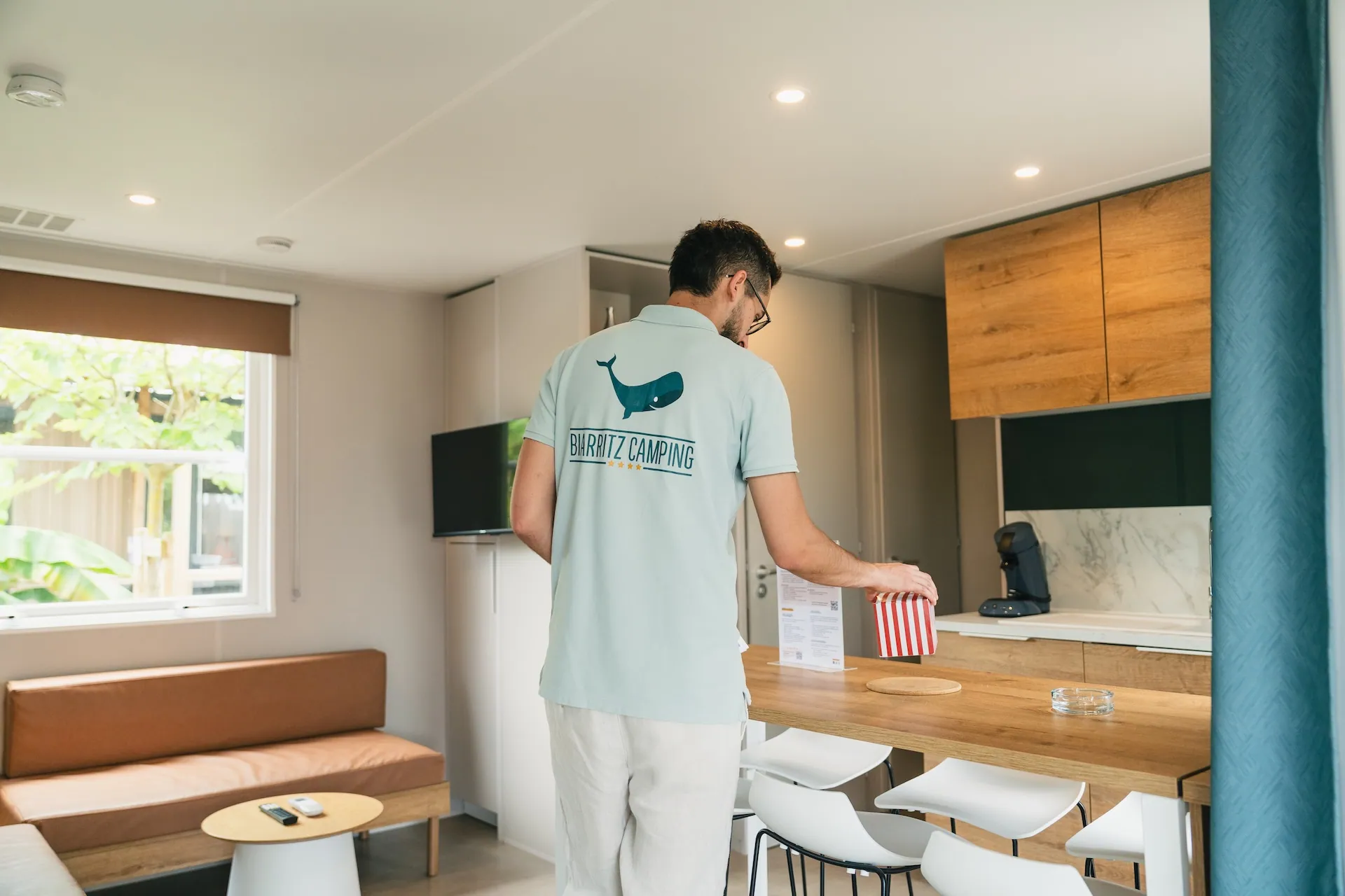 man wearing a Biarritz camping branded shirt in a rental unit