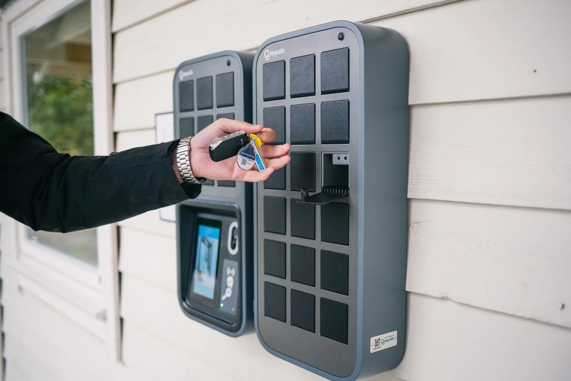 A person picking up a car key from the Keycafe locker system.