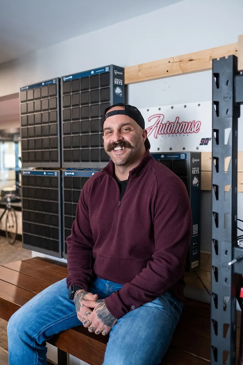 Ein Mitarbeiter von Autohouse Kingston sitzt und lächelt neben seinen SmartBoxes.