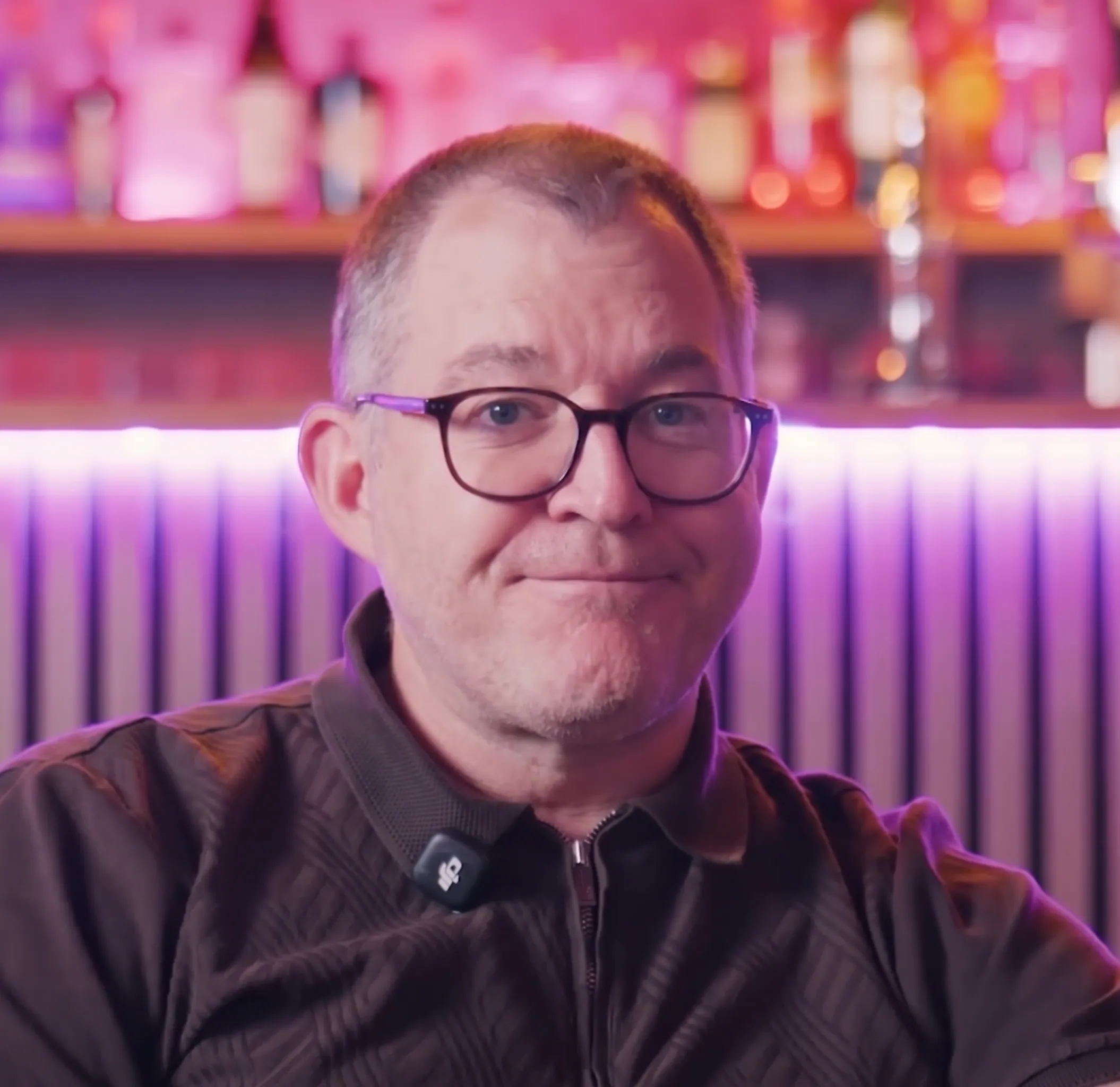 Daniel Pilley headshot in a hotel bar setting with pink ambient lighting.