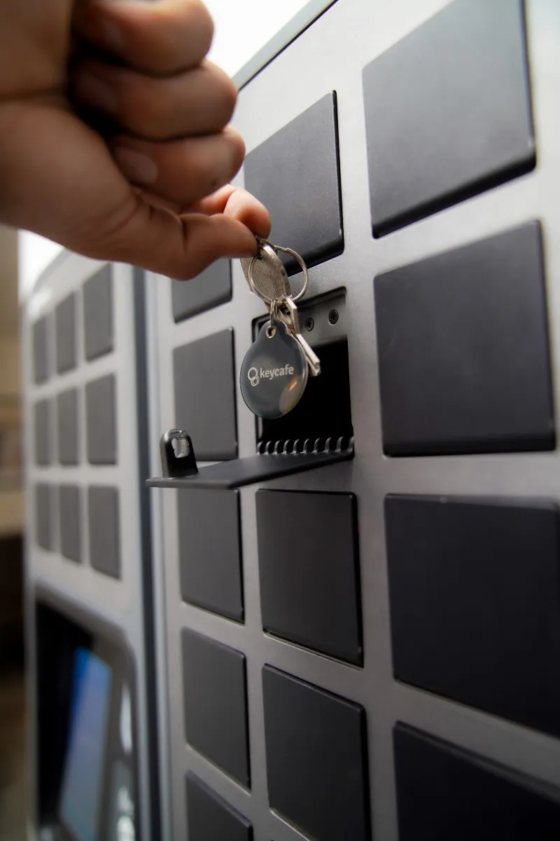 Primer plano de un empleado de Dynamic SLR sacando llaves de un compartimento SmartBox