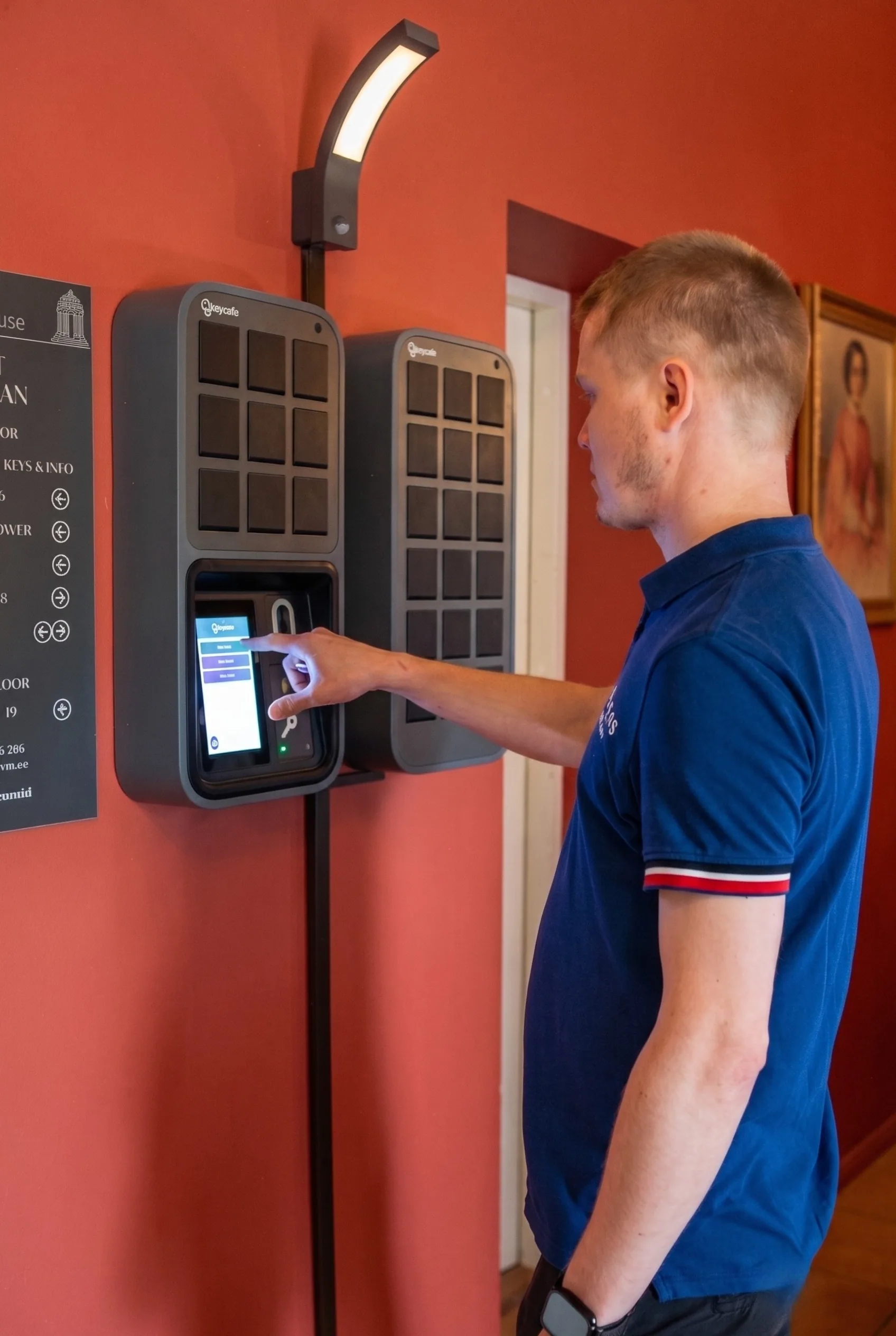 Gast nutzt das wandmontierte Keycafe SmartBox Schlüsselverwaltungssystem für den automatisierten Selbst-Check-in auf dem Gut Palmse.