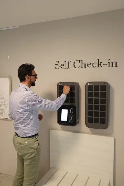 Hotel guest taking keys from a self-check-in Keycafe SmartBox in a hotel lobby