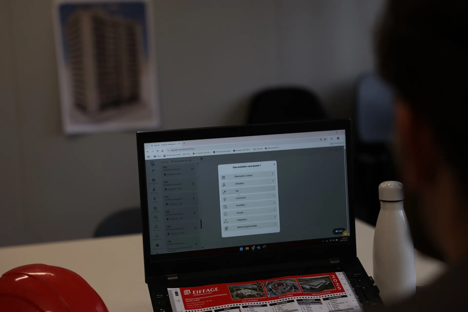 Construction worker looking at the Keycafe app on a laptop