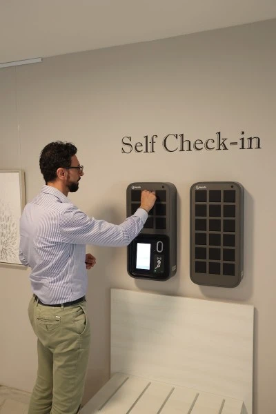Un ospite dell'hotel che ritira le chiavi da un Keycafe SmartBox per il self check-in nella hall di un hotel