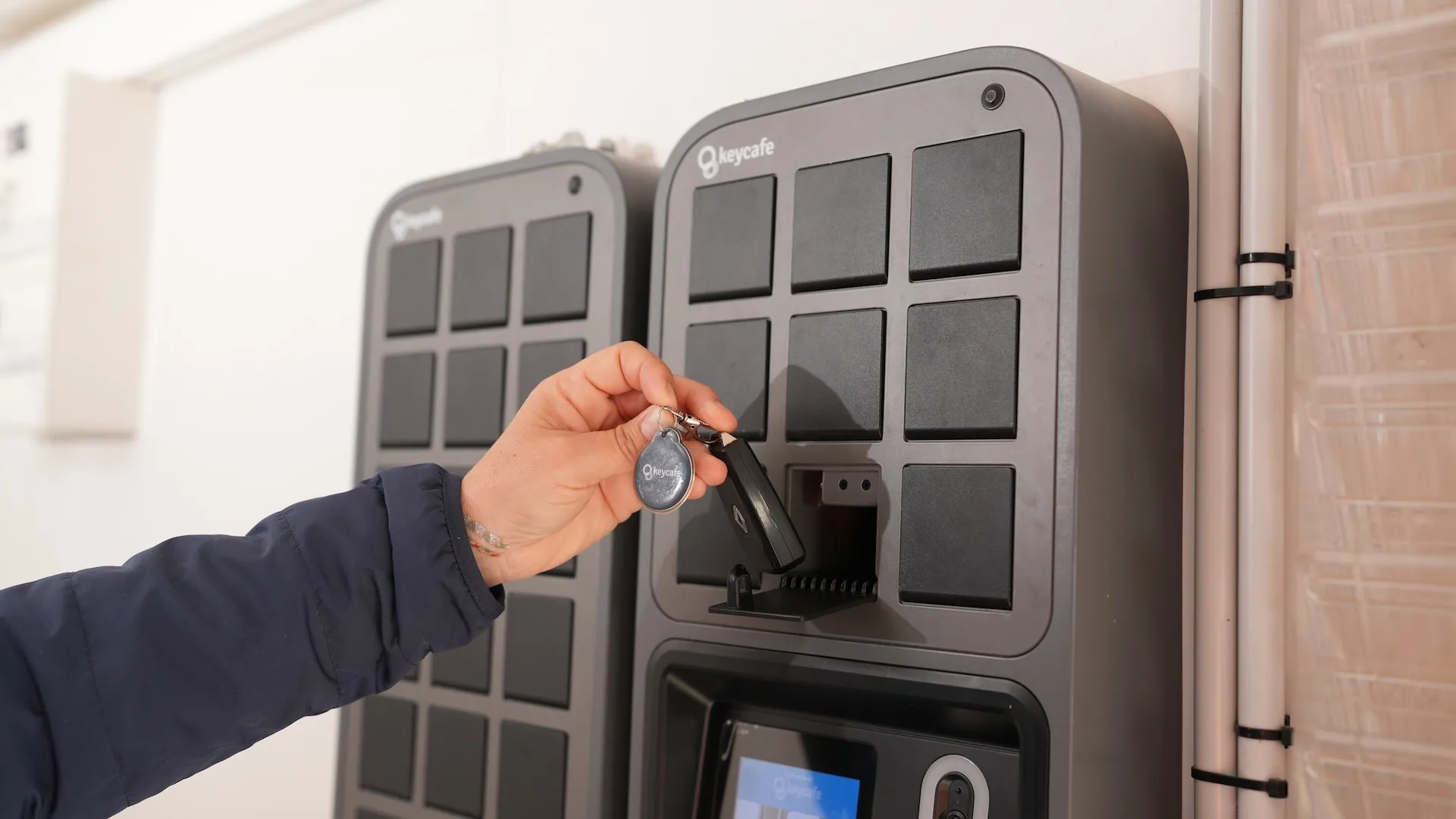 a hand picking up a key from the keycafe smartbox