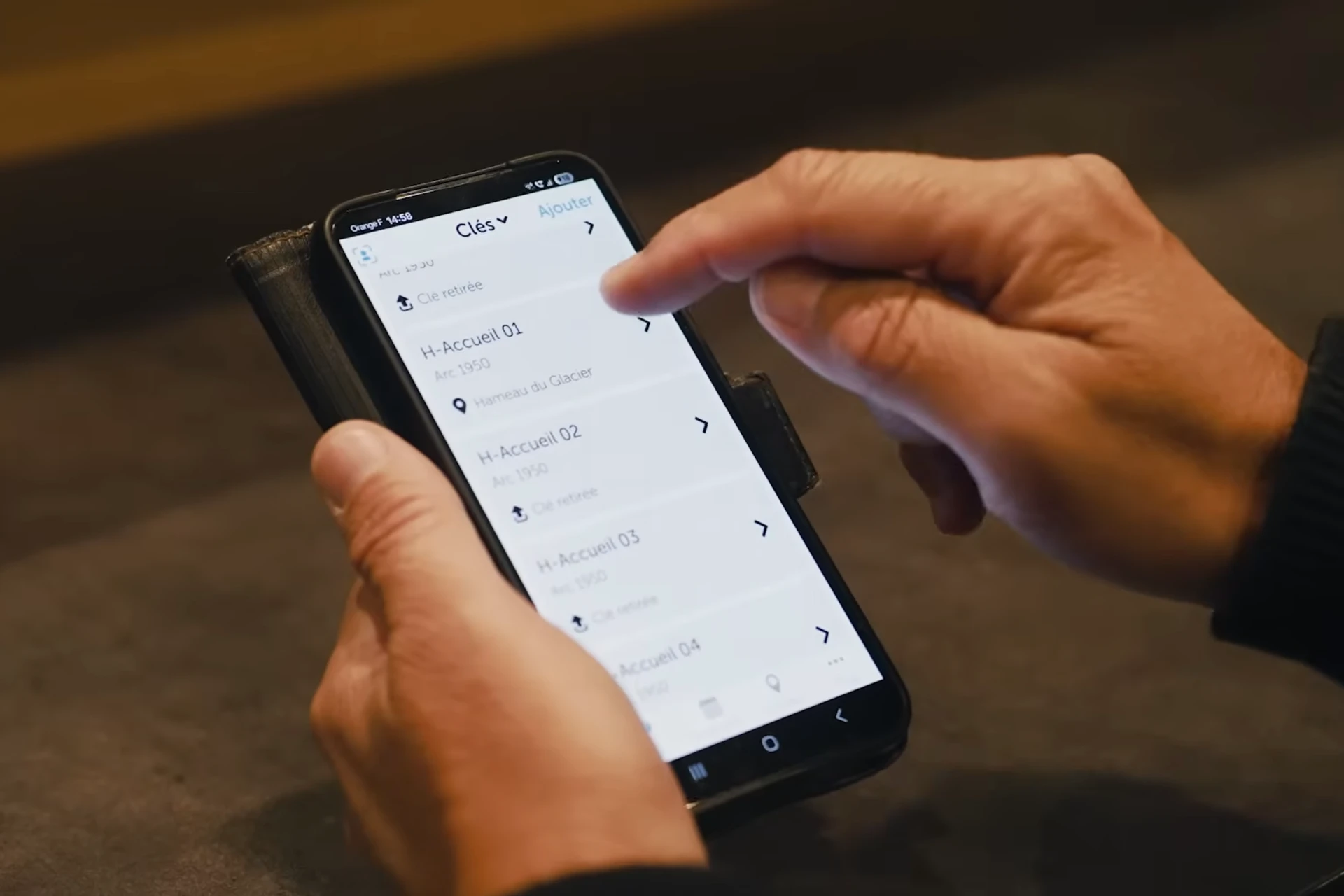 Hand holding a smartphone with the Keycafe app open