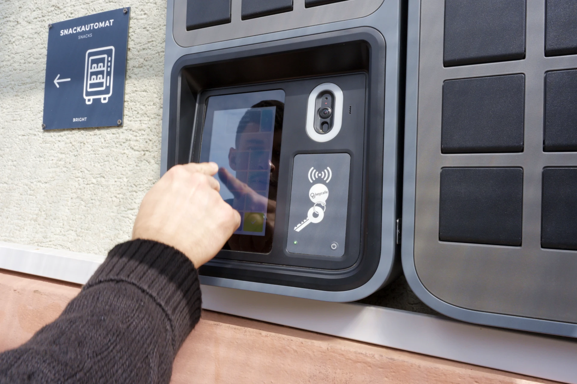A hand tapping a SmartBox screen