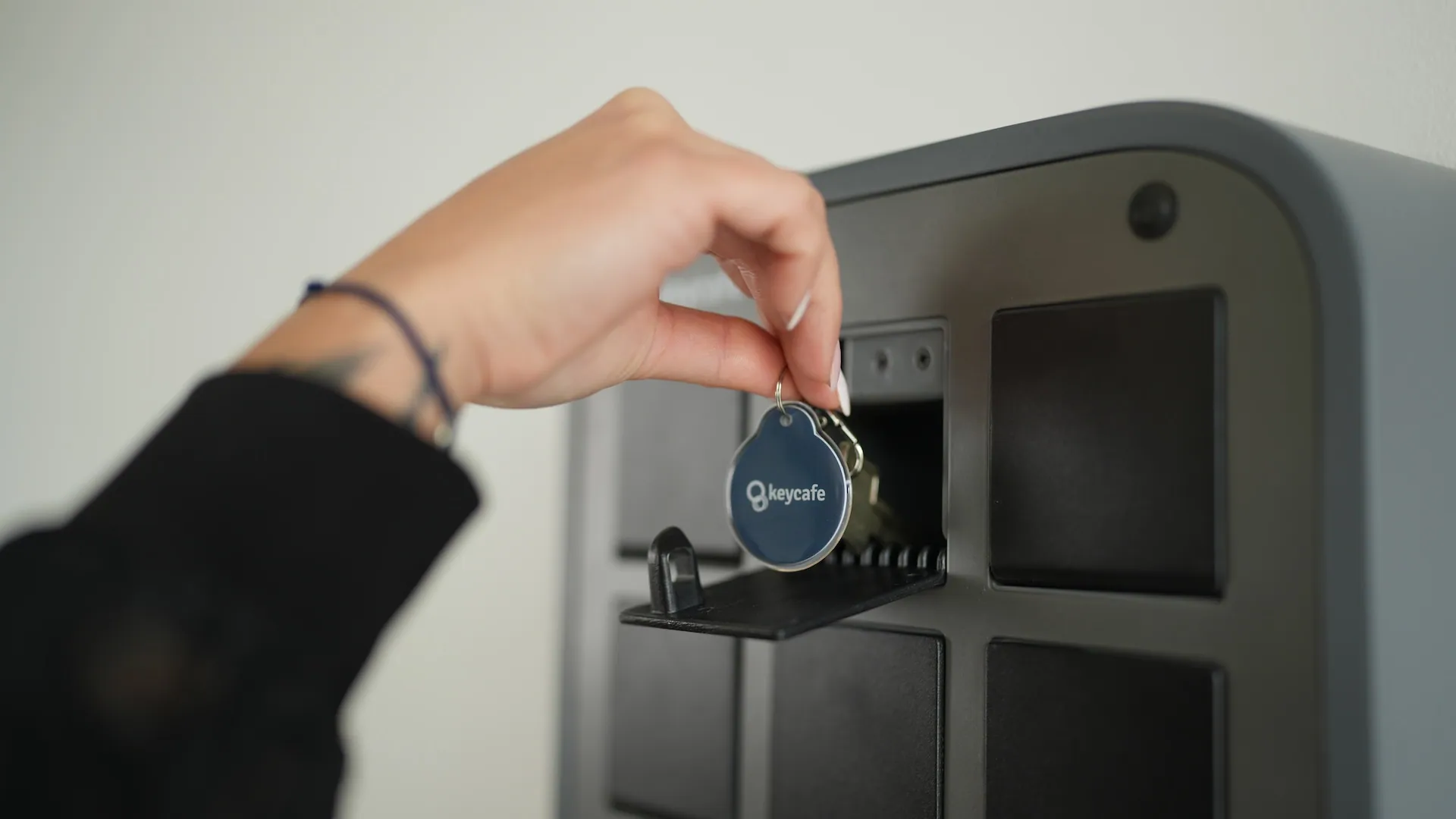 close up hand retrieving a key from the keycafe smartbox