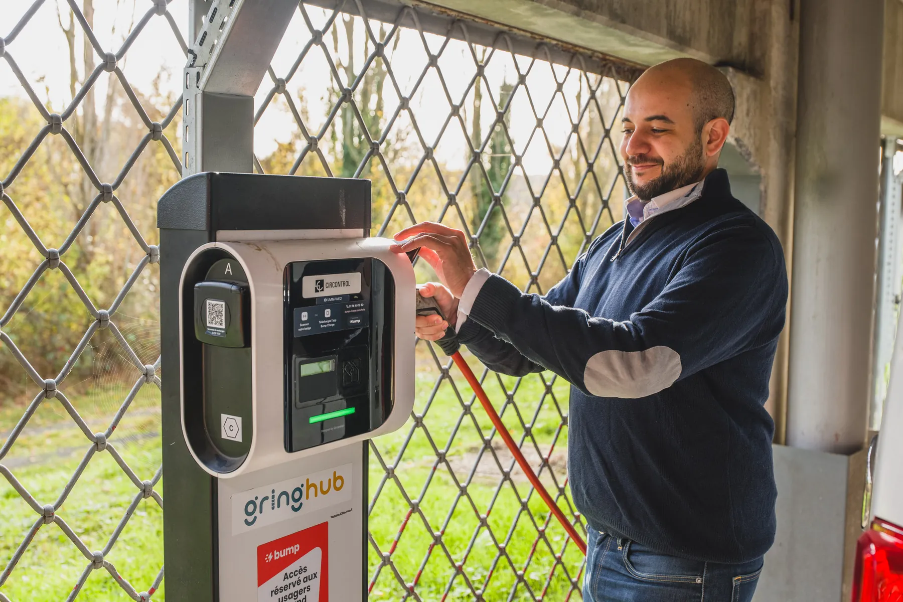 Kamel Fekhart plugging in a vehicle charging cable