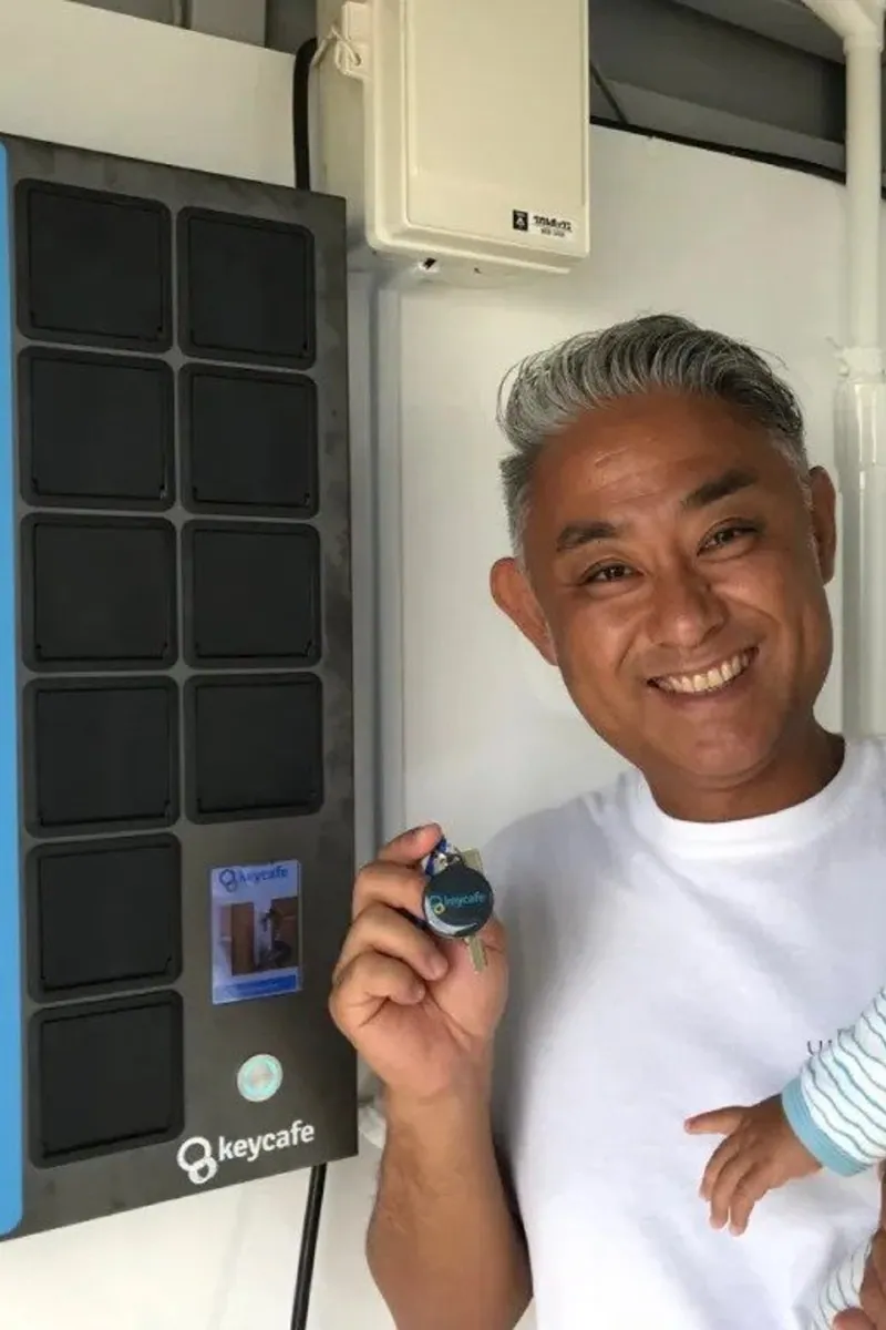 Manager Mr. Nakajima holding a Keycafe fob beside his SmartBox