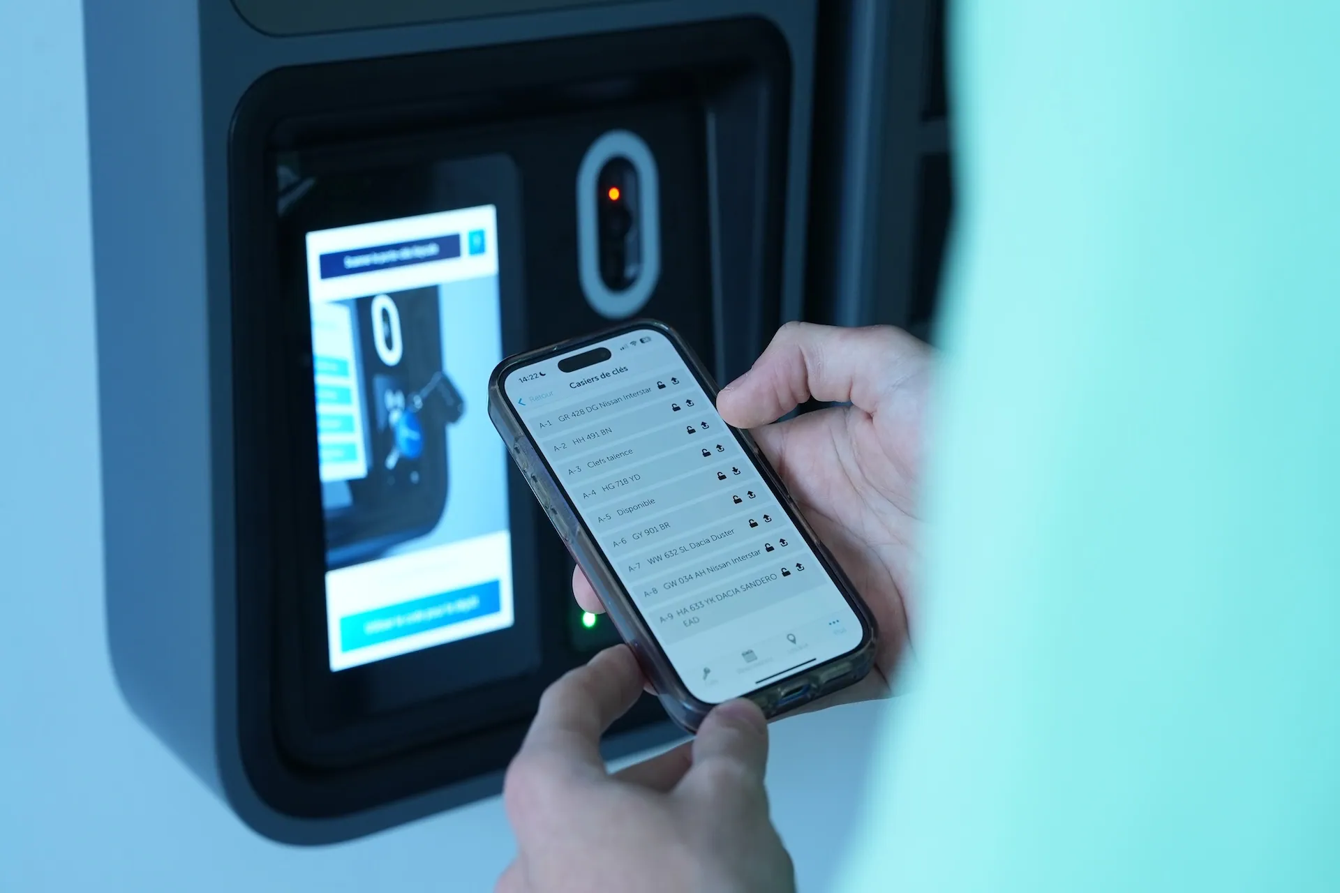 Holding a smartphone with the Keycafe app open at the SmartBox
