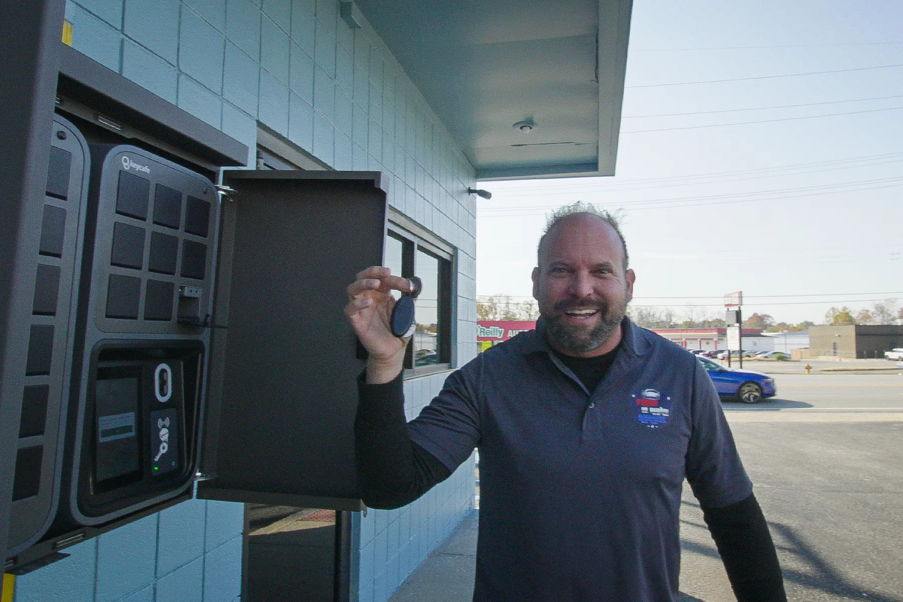 Joel Price holding a key with Keycafe fob next to the SmartBox