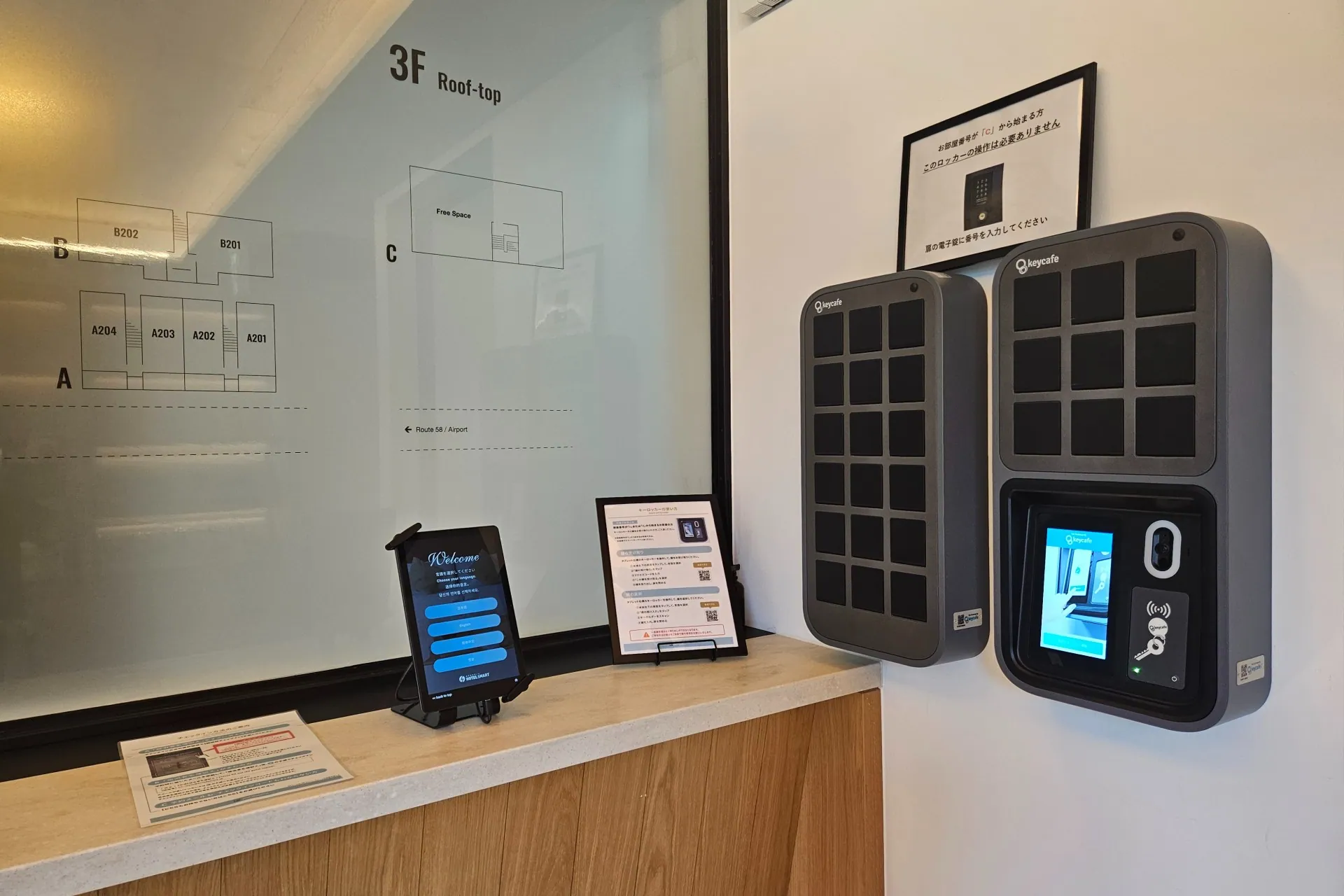 Wall-mounted SmartBoxes in the lobby beside welcome pamphlets and a property map