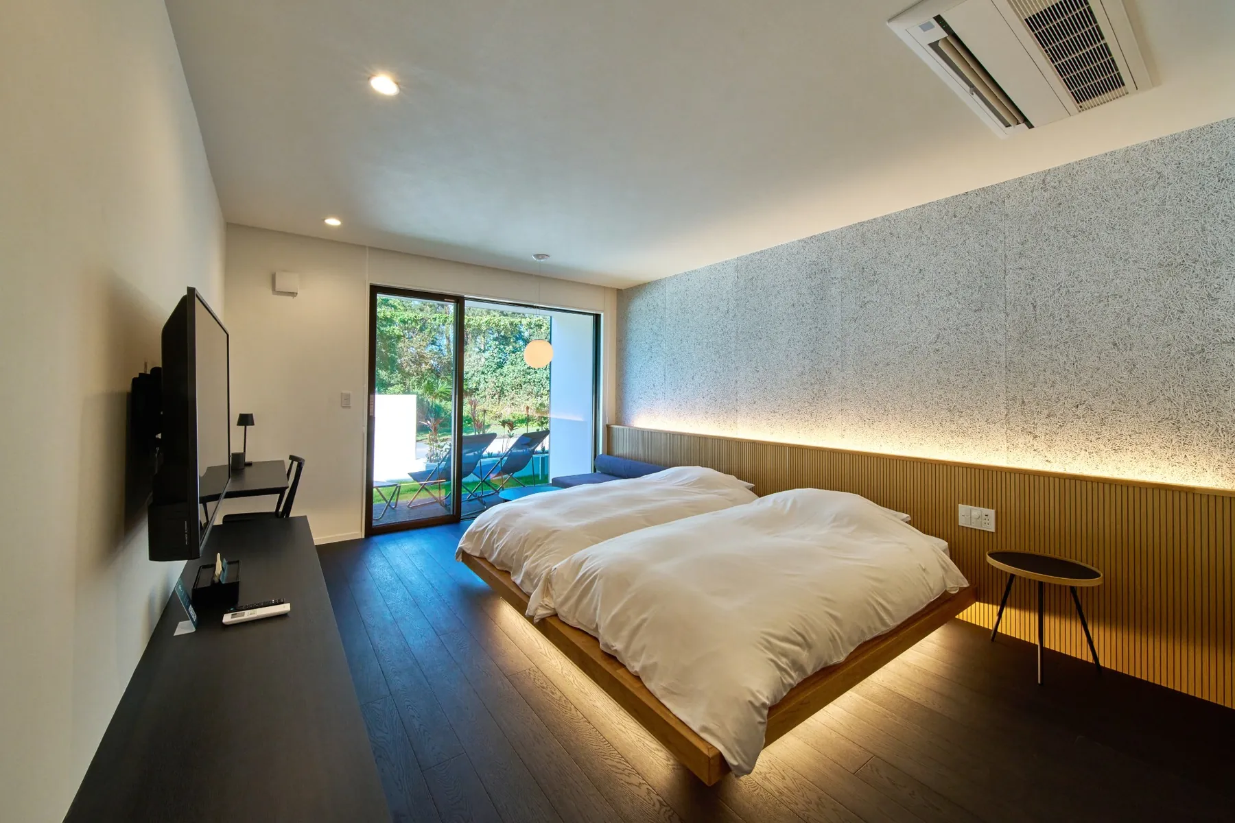 Interior of a LUXE TECH VILLA ASHITOKU room with two beds and ambient lighting