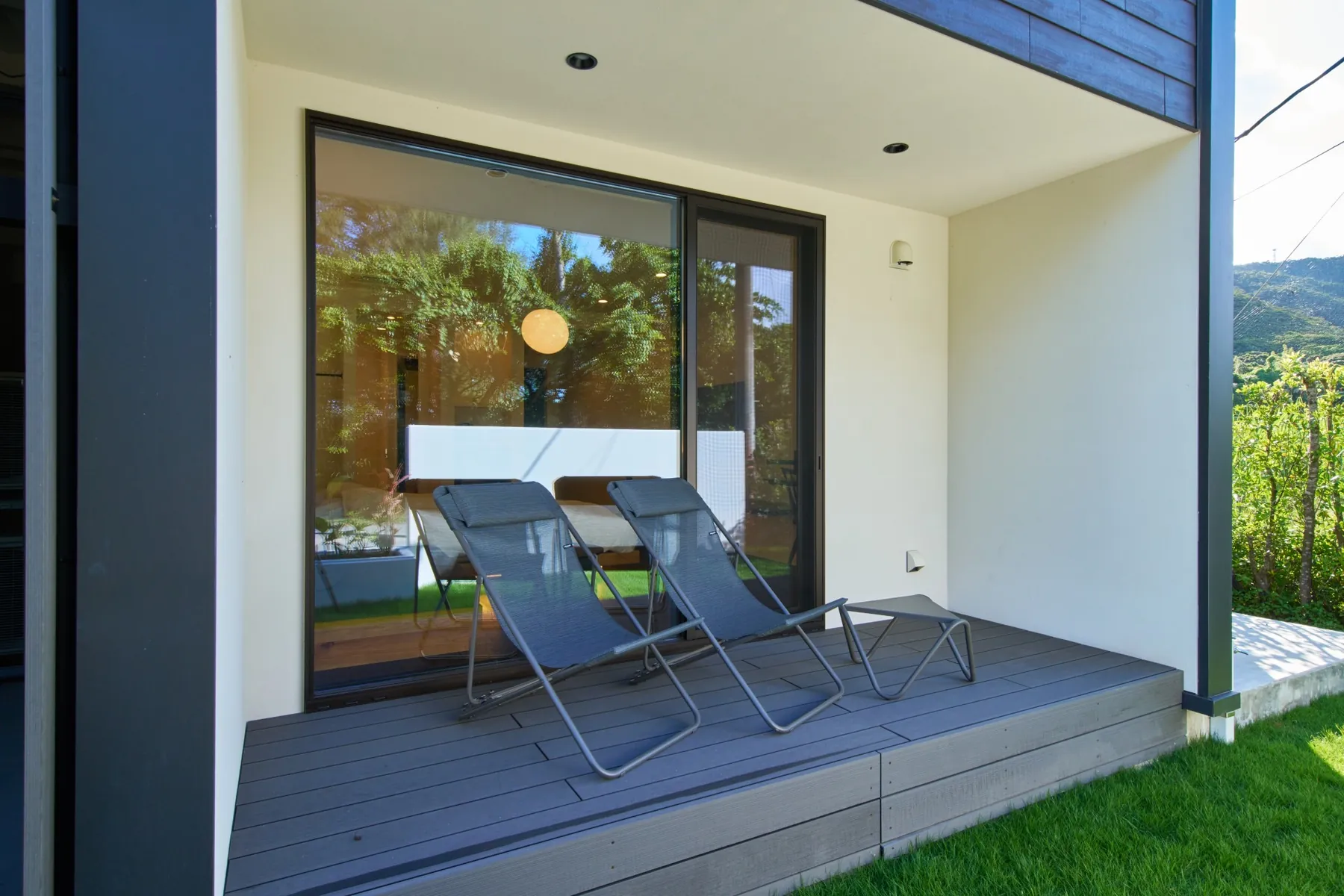 Outdoor patio of a LUXE TECH VILLA ASHITOKU room with two lounge chairs