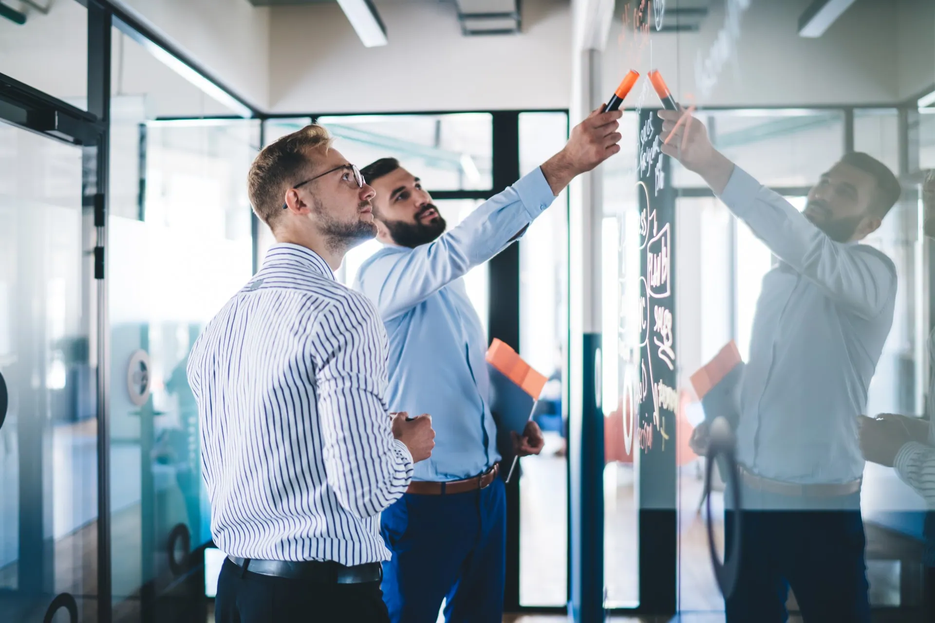 Two businessmen collaborating at a whiteboard