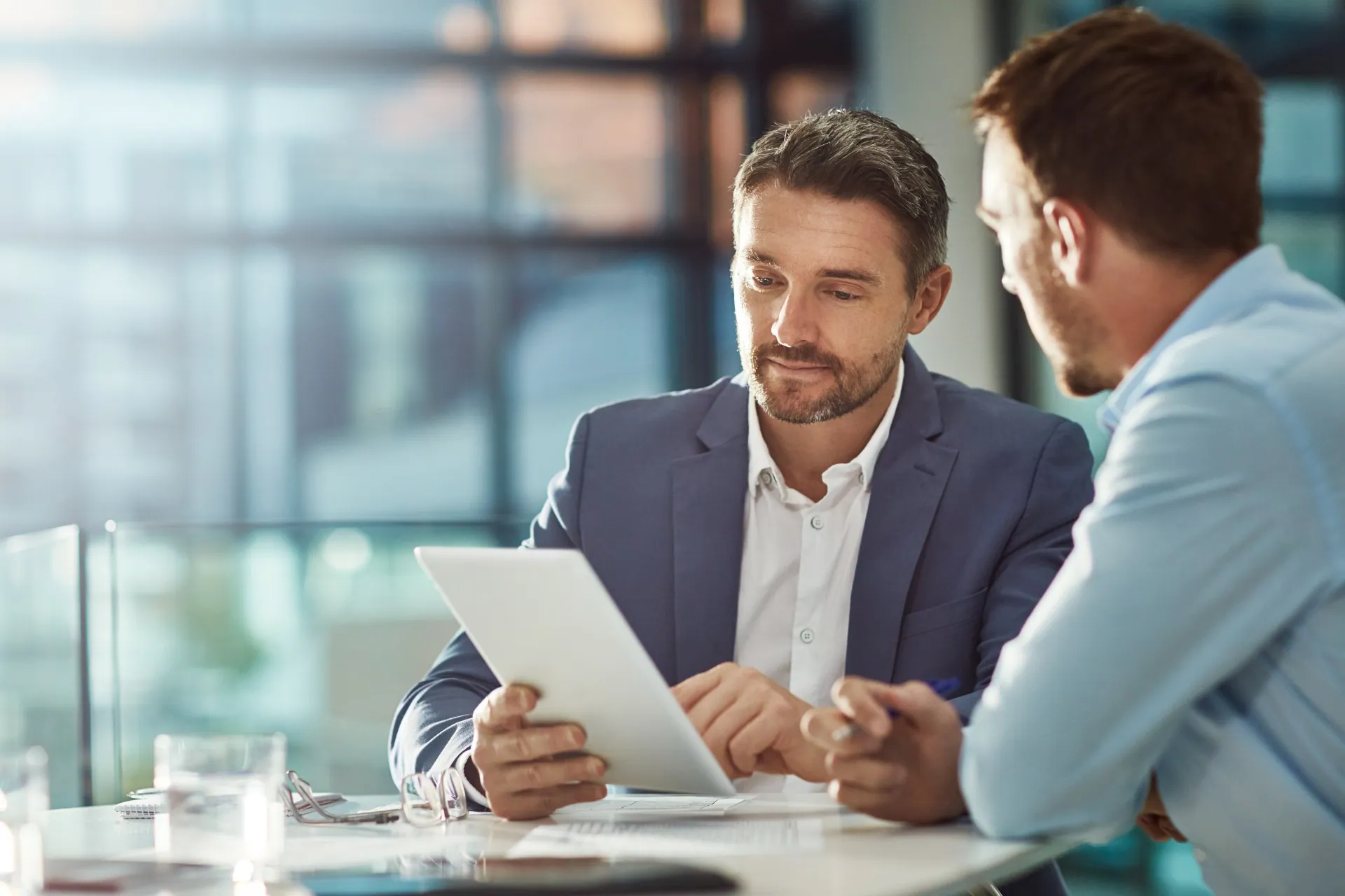 Two businessmen in conversation and looking at a piece of paper